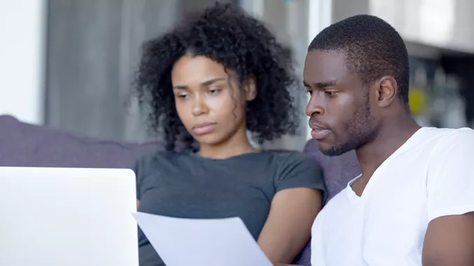 Black couple reading from a sheet of paper