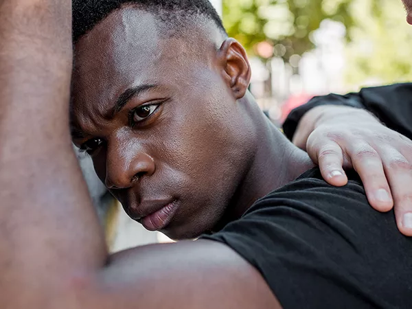 Young black man being searched by police officer