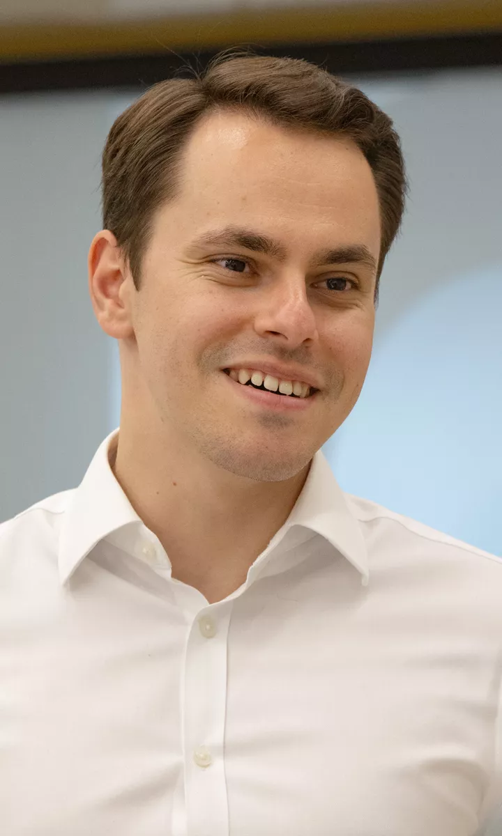 An IOPC male colleague smiles whilst speaking to a female colleague